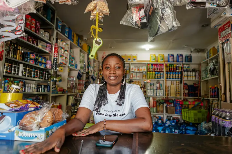 Une commerçante à son comptoir, prête à écrire à ses clients