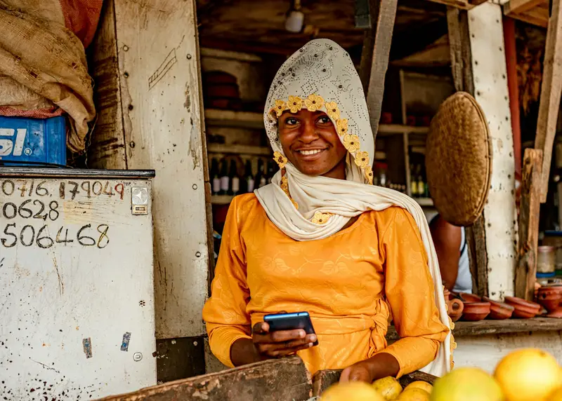 A shop owner smiling at her phone